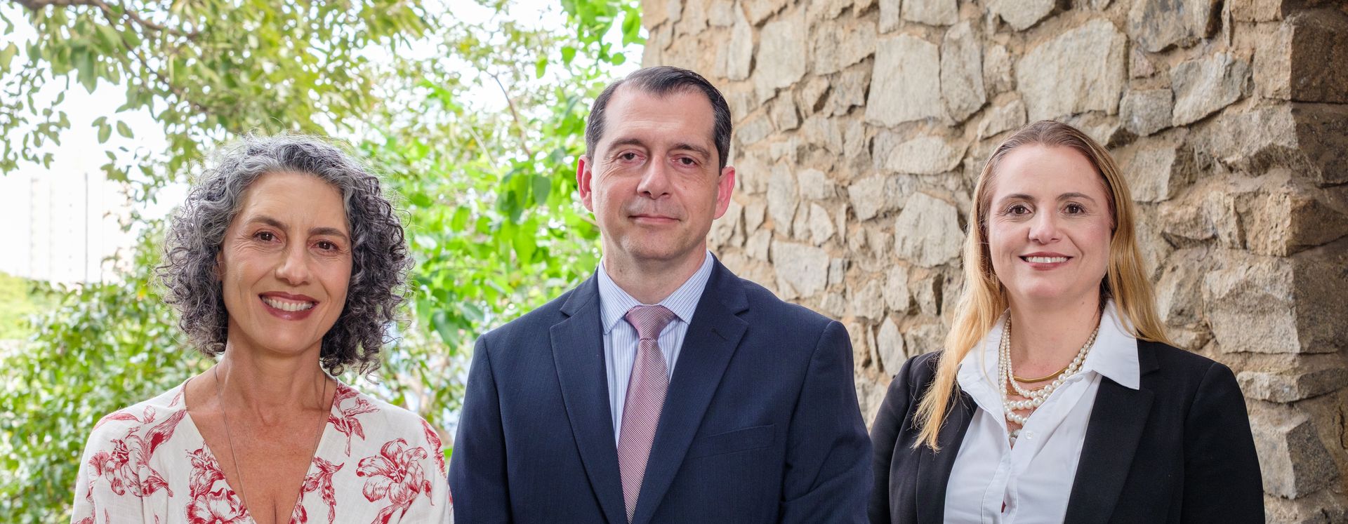 Iris Lippi, Fernando Fida e Fabiana Domingues Cardoso, sócios de LFD Advogados, diante do muro de pedra do escritório em Sorocaba